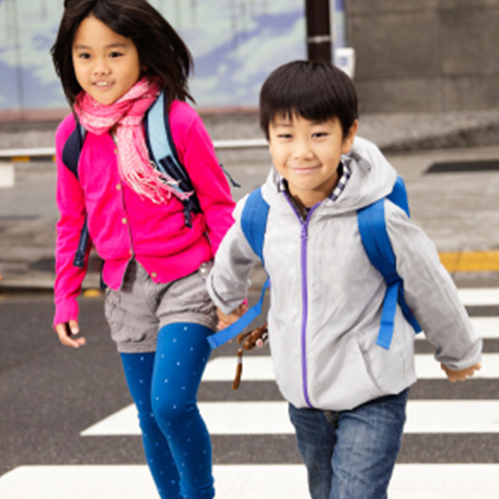 two children cross sidewalk