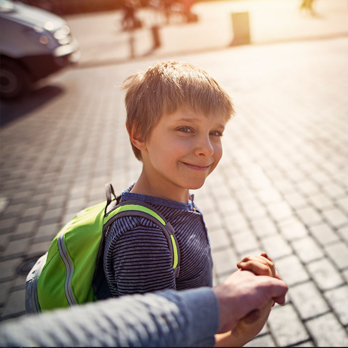  child crosses sidewalk